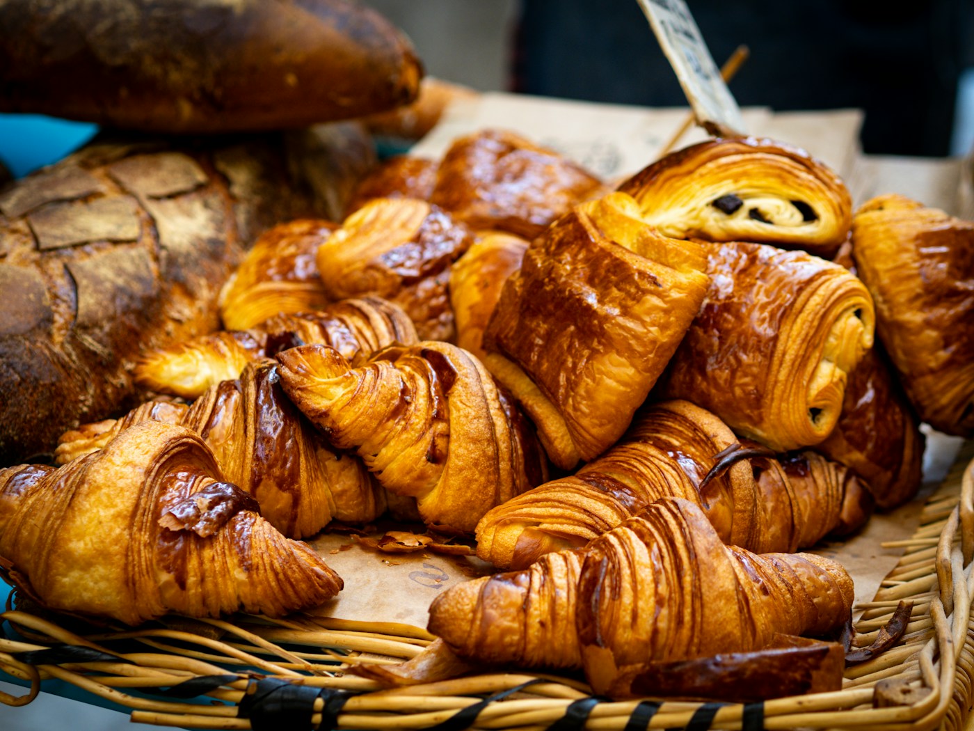 A basket of croissants, chocolate pastries and bread